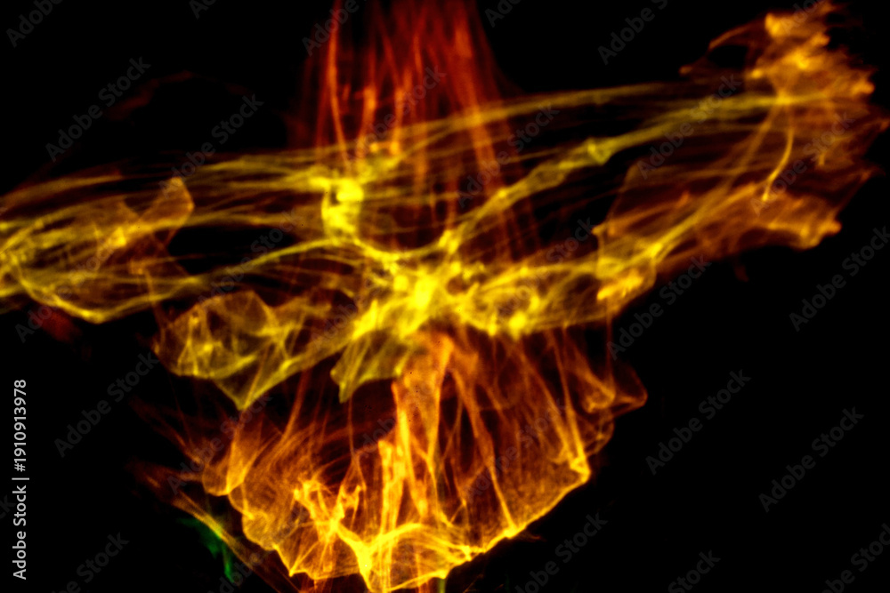 Fototapeta premium Abstract colorful smoke patterns in shades of yellow, orange, and green against a black background, creating a dynamic visual effect and fluid motion