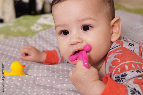 Wallpaper Mural Cute adorable newborn baby playing with colorful rattle toy. baby with teether. six months old lovely baby portrait on white with teether toy Torontodigital.ca