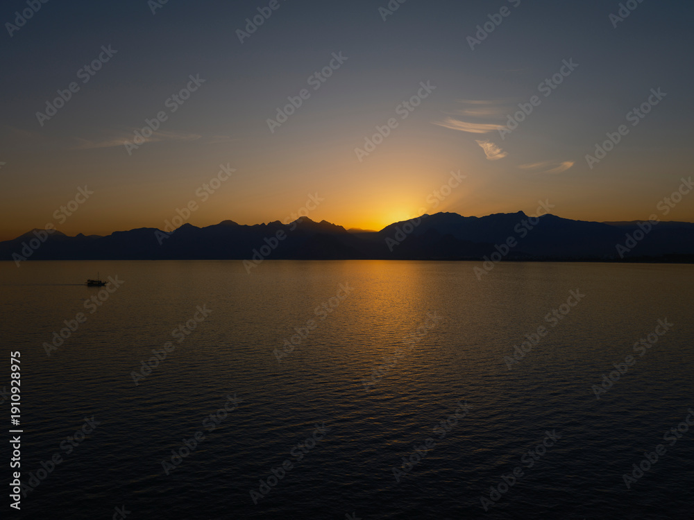 Fototapeta premium Scenic sunset view with mountains and serene ocean