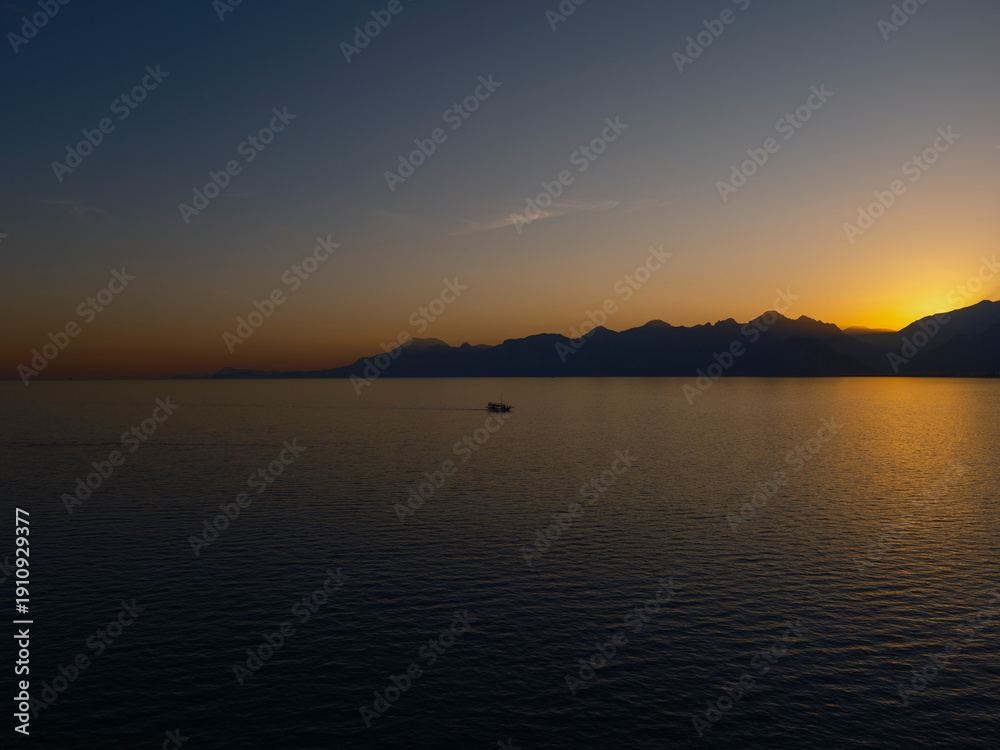 Obraz premium Scenic sunset view with mountains and serene ocean