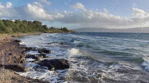 A lighthouse surrounded by rocks in a windy and choppy Aegean Sea. Akyarlar, Bodrum.	
