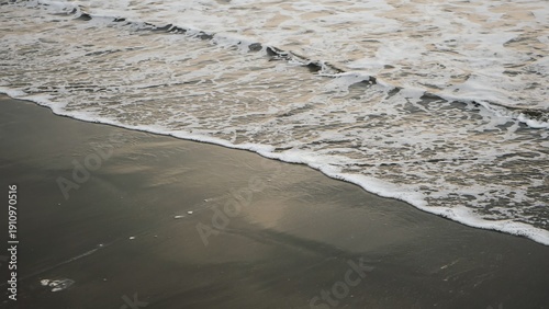 Wallpaper Mural Gentle wave ocean foam washing over dark wet coastal sand Torontodigital.ca