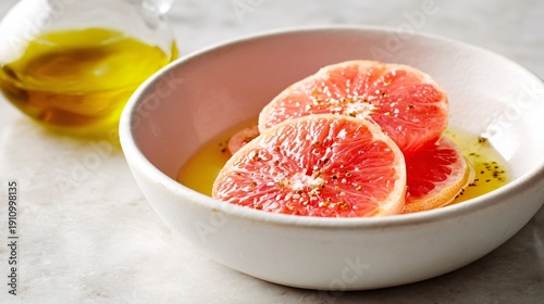 Citrus vinaigrette with grapefruit notes, pinkish hue, white ceramic bowl on light stone surface