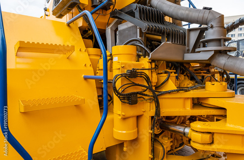 Принти на полотні Detailed view of a hydraulic system, steering cylinders, and articulation joint on a yellow industrial loader
