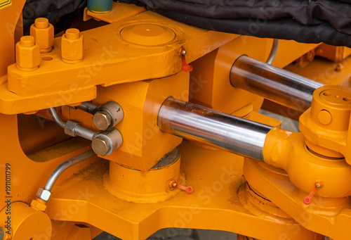 Cuadro en lienzo Close-up of powerful hydraulic cylinders and articulated joint on yellow industrial machinery
