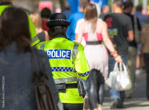 Slika na platnu Female police officer patrolling a street in
 the Uk.