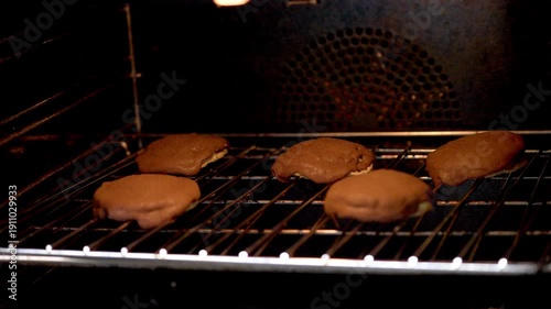 Freshly Baked Coffee Buns with Crispy Topping Cooling Inside a Warm Oven
