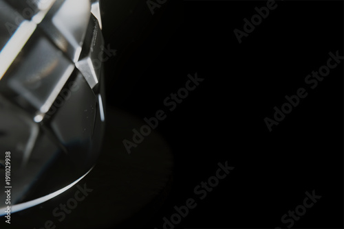 Abstract 3d geometric object reflecting light on black background