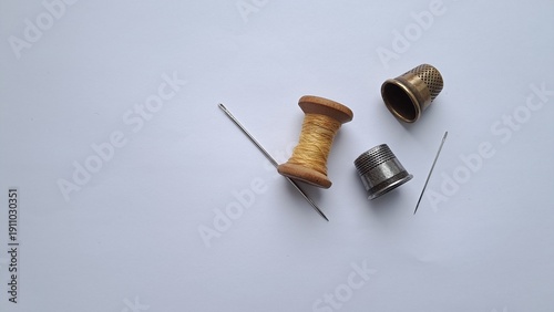 Thimble, Needle and Wooden Spool on Light Background. Thimble, Needle and Wooden Spool on Light Background