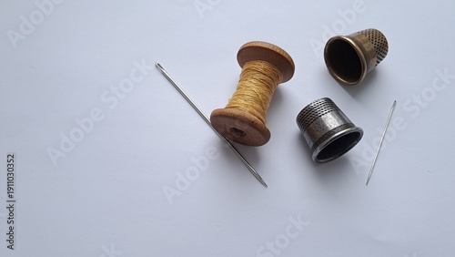 Sewing Tools with Needle and Thimble on Neutral Background