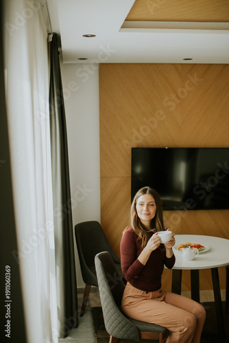 Smiling woman enjoys coffee...