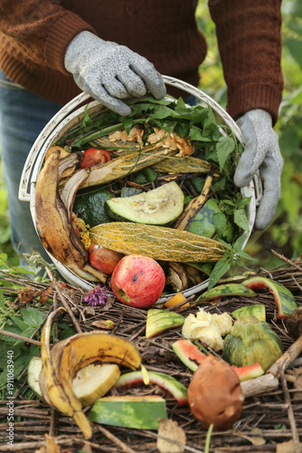 Food waste, scrap of vegetables and fruits in bucket for compost close up. Farmer composting in compost heap pile, zero waste concept
