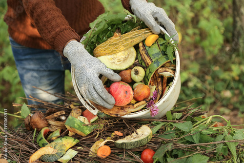 Food waste, scrap of vegetables and fruits in bucket for compost close up. Farmer composting in compost heap pile, zero waste concept