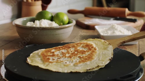 Preparing homemade tapioca crepe on griddle