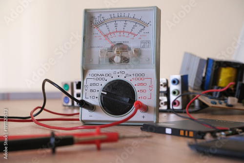 Foto Electronics repair and restoration workbench with analog multi meter