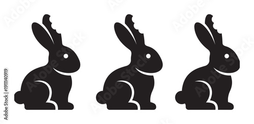 Three black chocolate Easter bunny silhouettes with a bite mark on one ear are arranged in a row in this minimalist graphic illustration for the spring holiday season