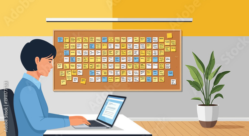 Man working on laptop in office with calendar on wall and plant nearby indoors