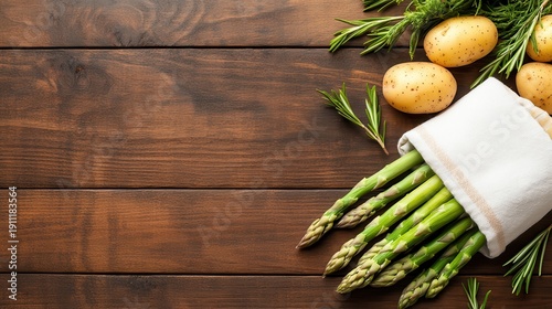 Fresh organic green asparagus and potatoes on dark wood surface