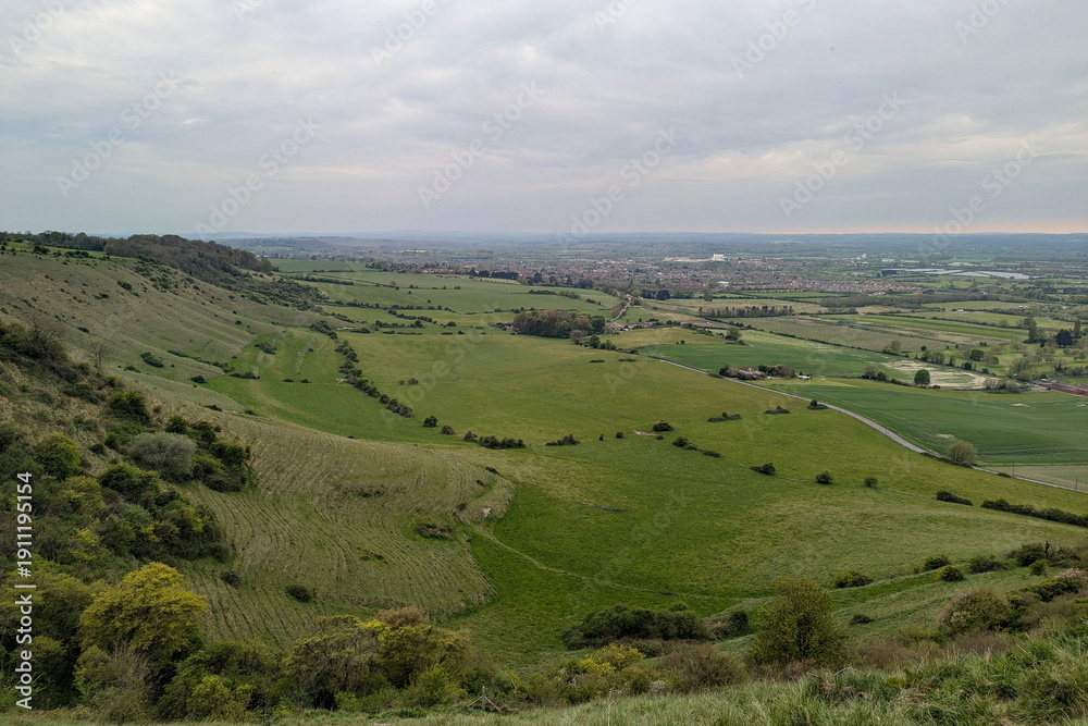 Obraz premium Scenic landscape view of green farmland fields seen from the Salisbury Plain in Wiltshire England