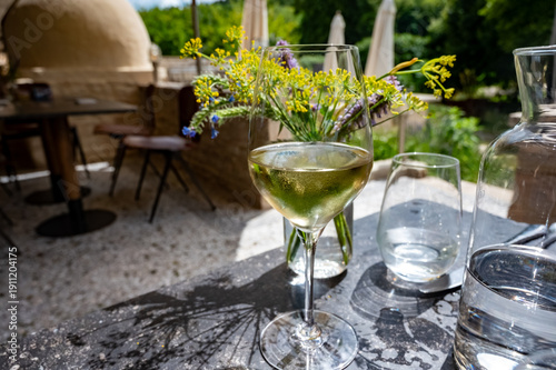Tableau sur toile One white wine glass served outdoor on sunny French cafe terrace in summer, vaca