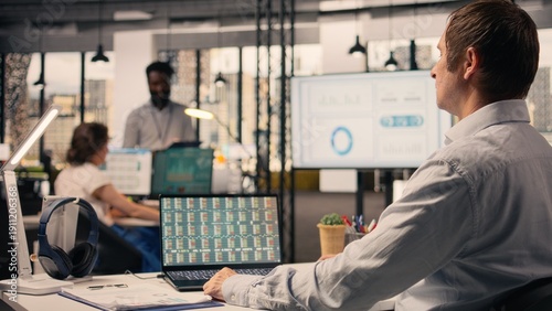 Professional man, business intel, visual data in office, analytics dashboard, performance metrics, forecasting reports, assisting with monetary data, resource allocation, and strategy planning.