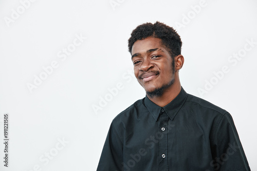Foto Young black man with dark skin wearing black shirt smiling confidently on white background