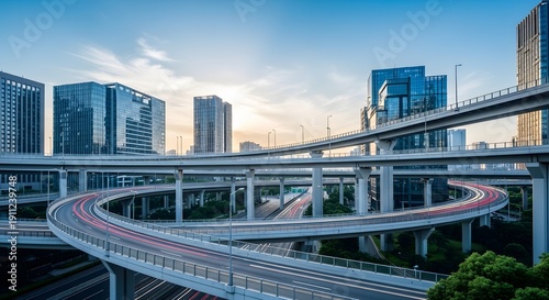 Modern city skyline with multi-level highway interchange and light trails at dusk.