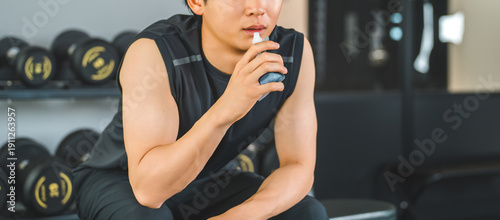 Quadro em tela Young Asian man drinking jelly drink to refuel after training at the gym