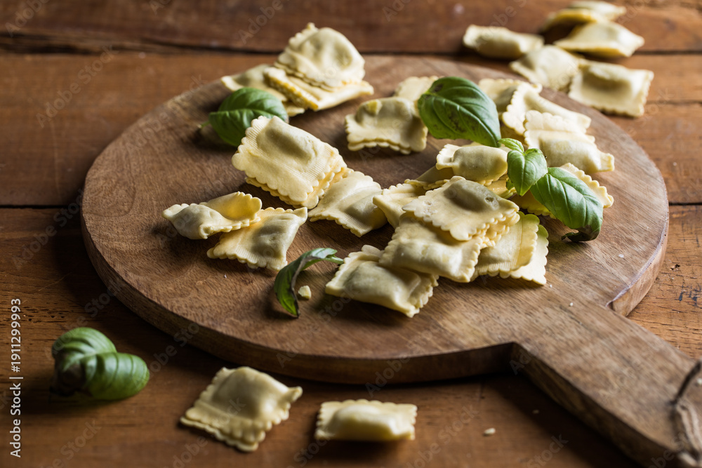 Fototapeta premium Fresh raw ravioli pasta on a rustic wooden table, natural light, artisanal food styling