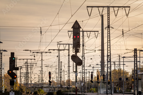 Recently reconstructed railway tracks and modernized platforms at a suburban station in Germany, with new structures, overhead wires and multiple signal lights forming an infrastructure grid at sunset