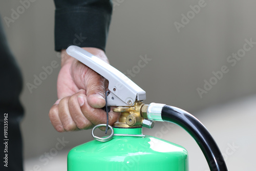 Fire extinguisher safety emergency training hand handle hose pin, closeup of person gripping trigger for workplace fire prevention and readiness