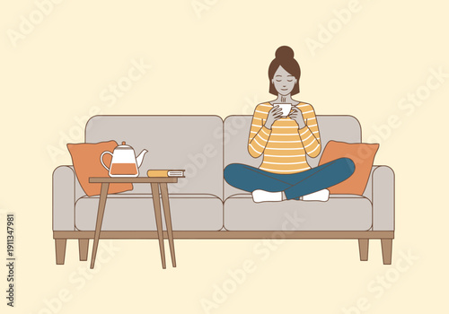 Relaxed Woman Sitting Comfortably On Sofa Enjoying Cup Of Tea Indoors With A Small Table Next To Her Holding A Modern Teapot