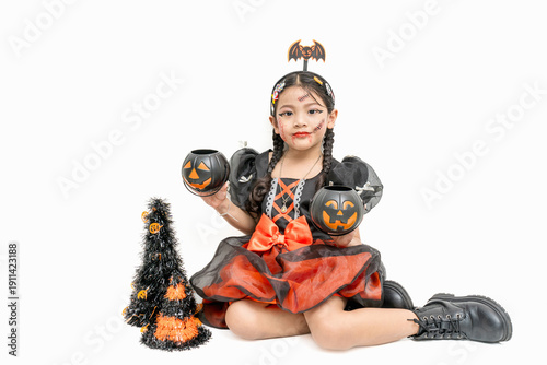 Cute Asian girl dressed up for Halloween, posing for a photo on a white background.
