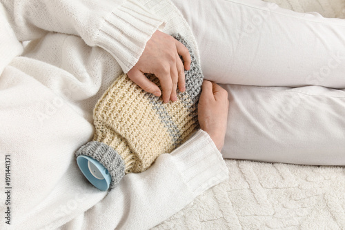 Woman warming her belly wit...