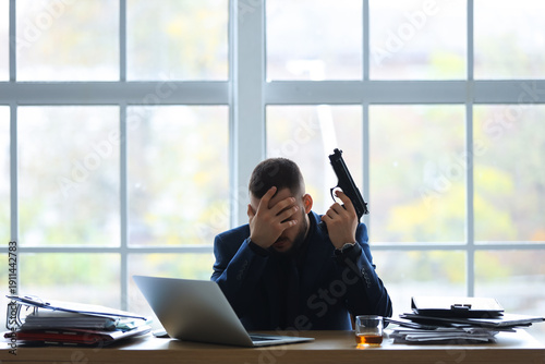 Businessman with gun at des...