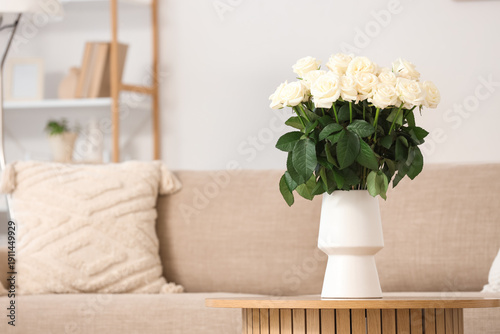 Vase with white roses on ta...