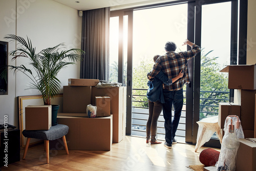 Foto Glass door, boxes and couple with hug in new home for moving in, mortgage success and balcony view