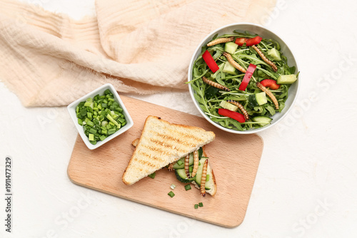 Fotografía Sandwich with fried maggots and bowl of fresh salad on white background