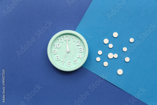 Cuadro en lienzo Alarm clock with sleeping pills on blue background