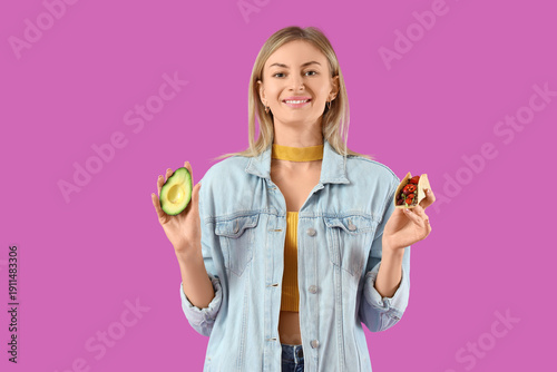Young woman with tasty taco...