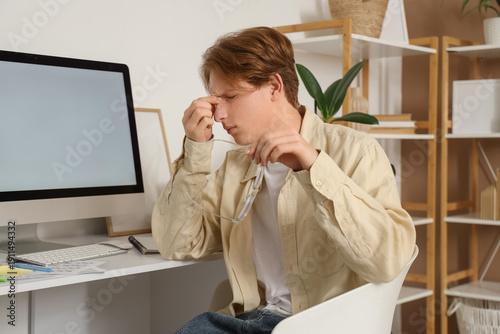 Tired male student with eye...