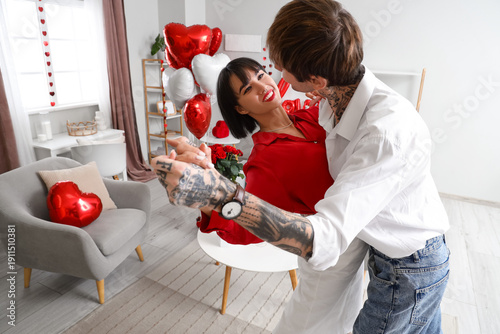 Young couple dancing at hom...