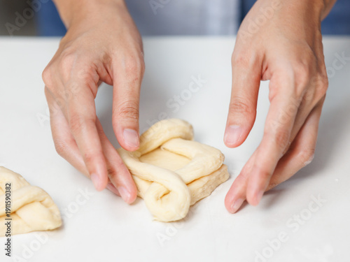 Closeup hand of woman bakers chef shaping folding puff pastry dough pie on white table process making workflow ingredients flour delicious homemade sweet dessert bread baking cooking in bakery kitchen