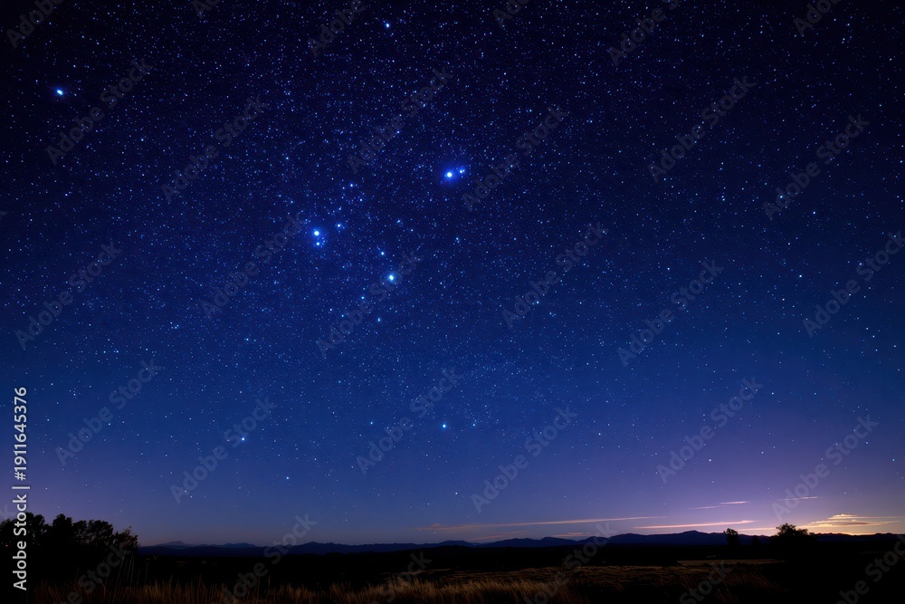 Fototapeta premium Astro nightscape highlighting the Southern Cross in a deep blue sky with distant silhouettes