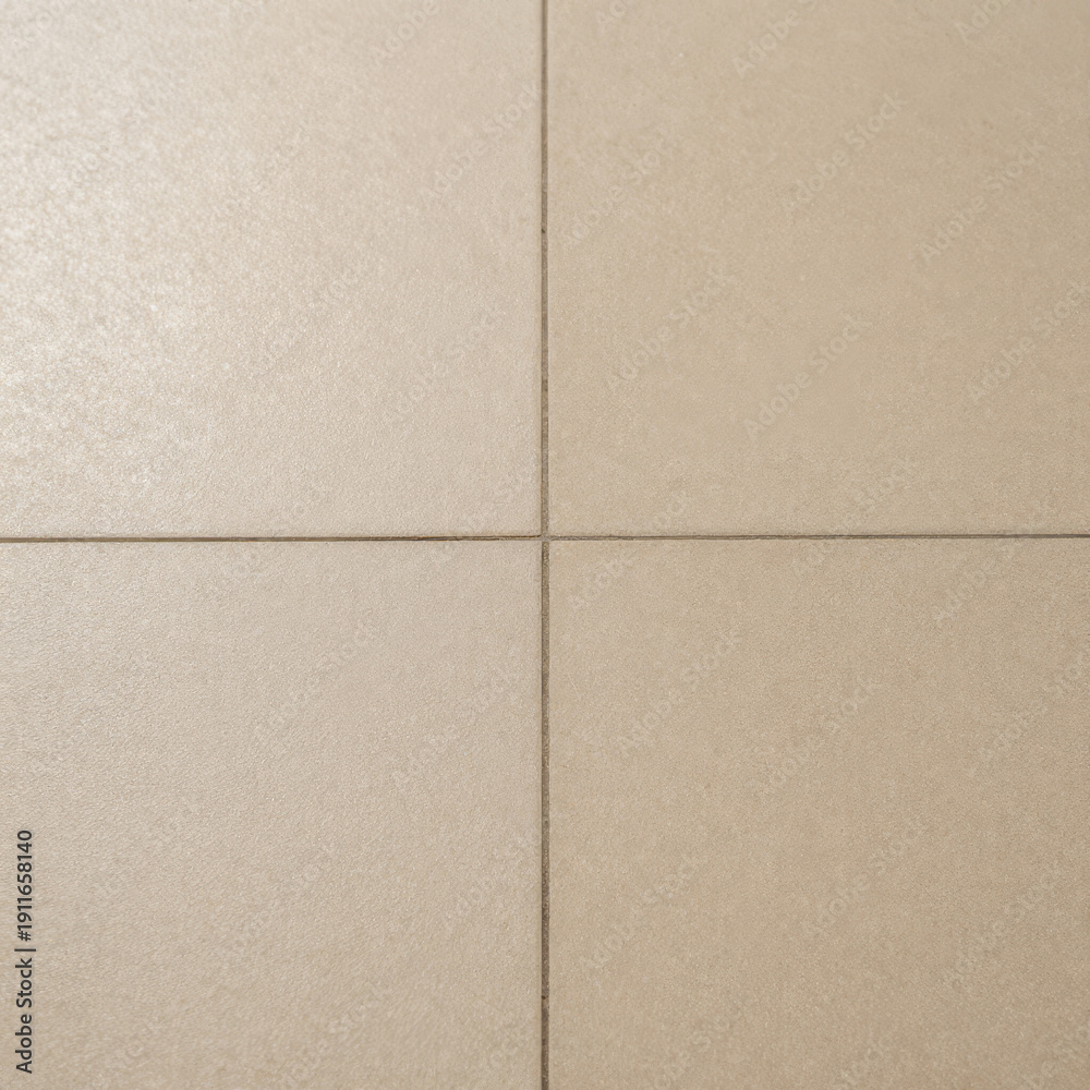 Fototapeta premium Square ceramic tiles with visible grout lines and light surface staining from wear