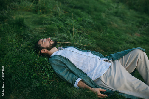 man with beard lying on grass