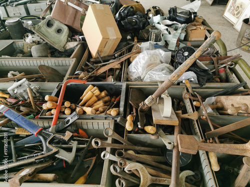 Картината върху платно A cluttered metal bin is filled with a variety of vintage tools, rusty wrenches,