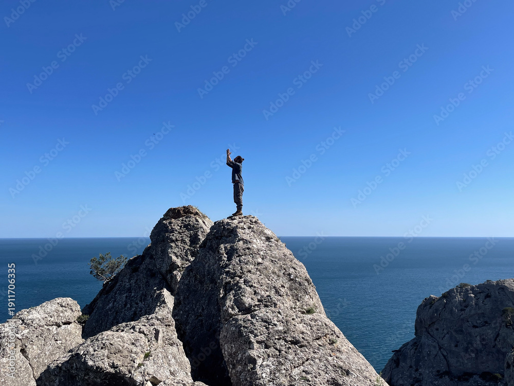 Obraz premium man stay on the rock on sea
