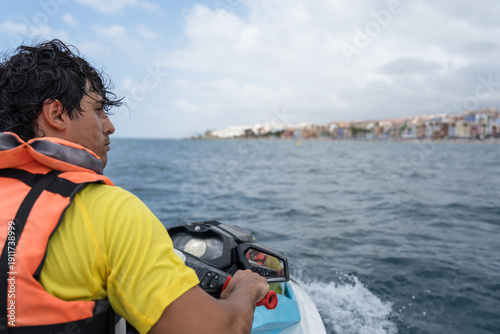 Foto Lifeguard patrolling beach on water scooter looking for swimmers in danger