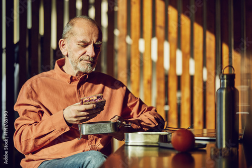 Relaxed businessman having sustainable lunch in his office
